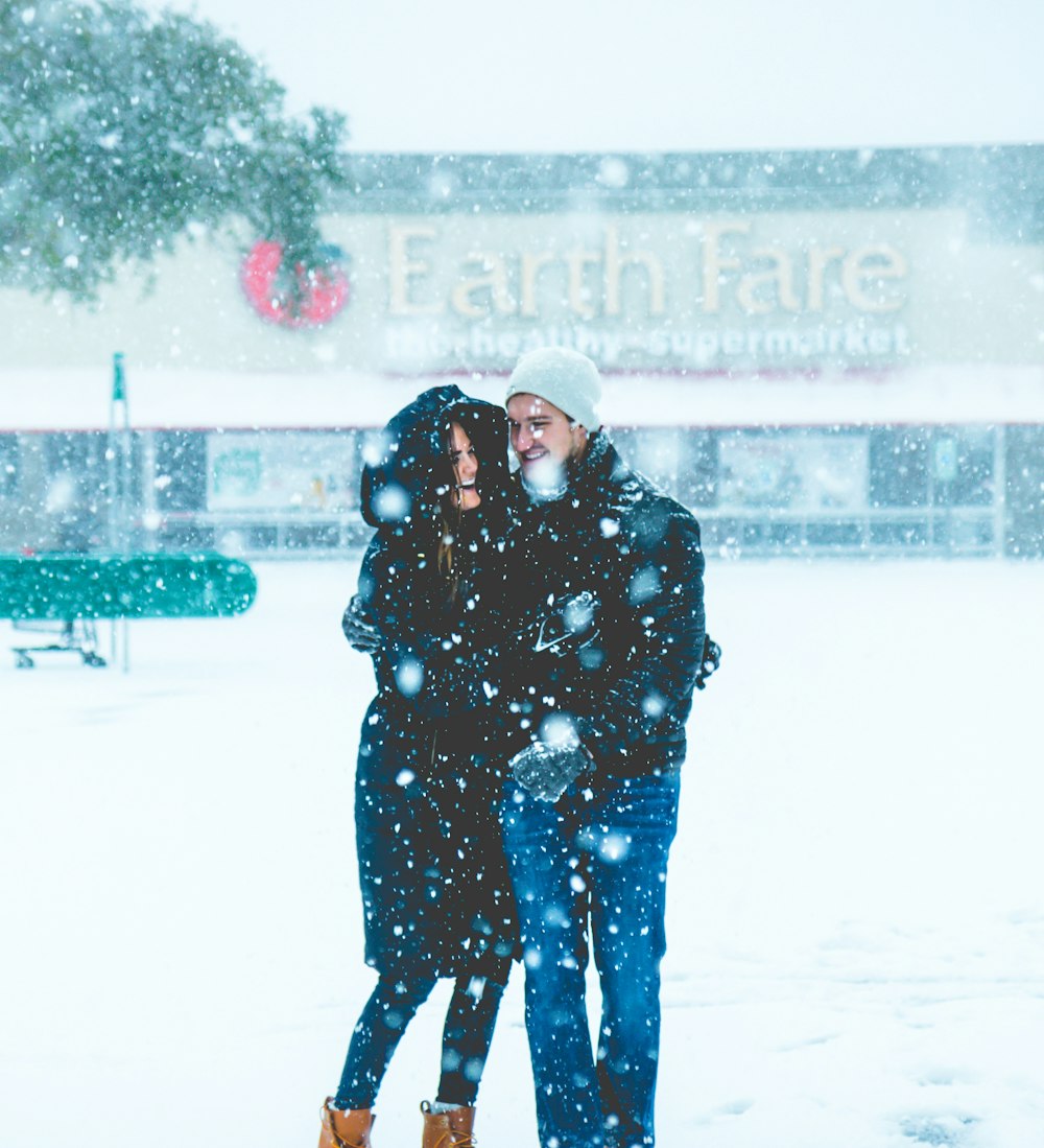 woman and man standing on snowfield