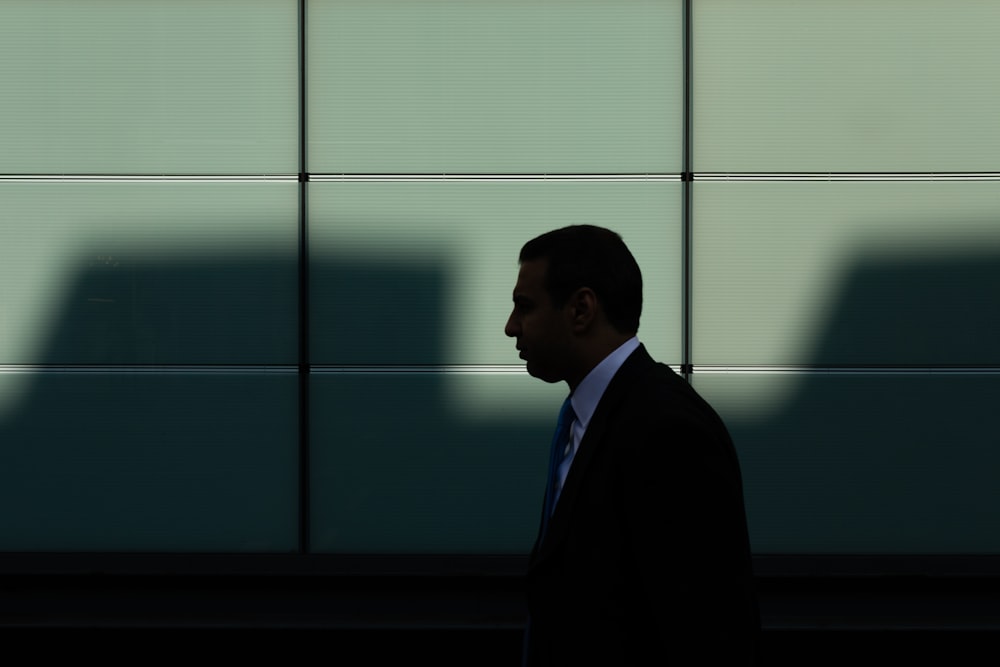 man walking near gray concrete wall