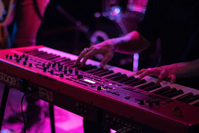 Keyboardist fingers dancing above keys with colorful background hues.