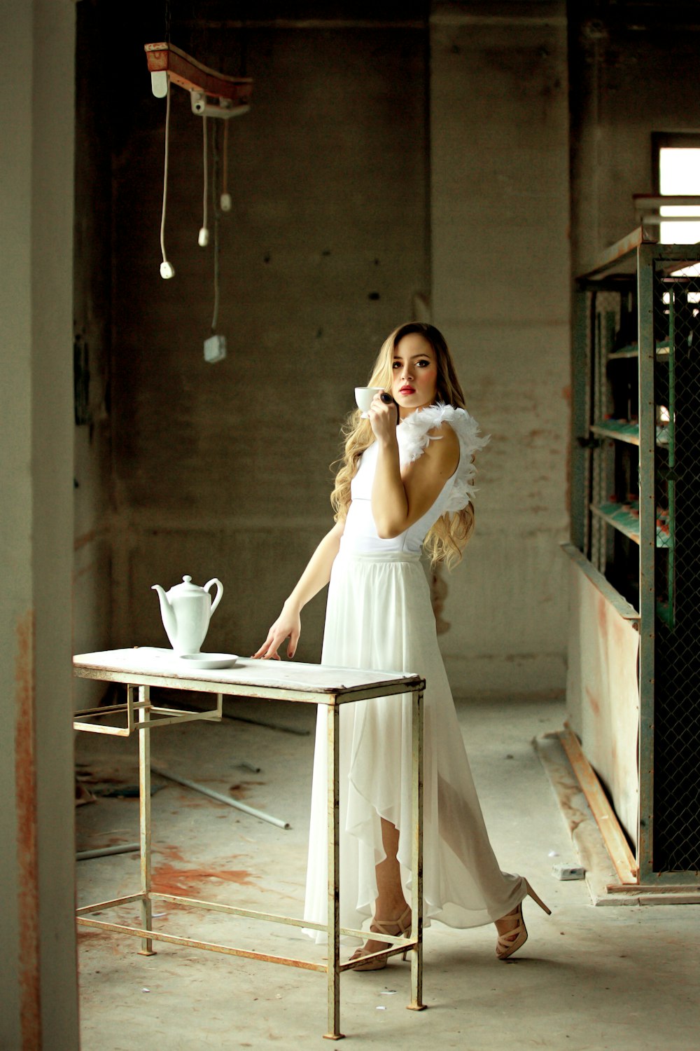 woman holding ceramic cup near table