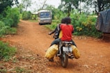 Children riding ATVs along a dirt trail surrounded by green fields.