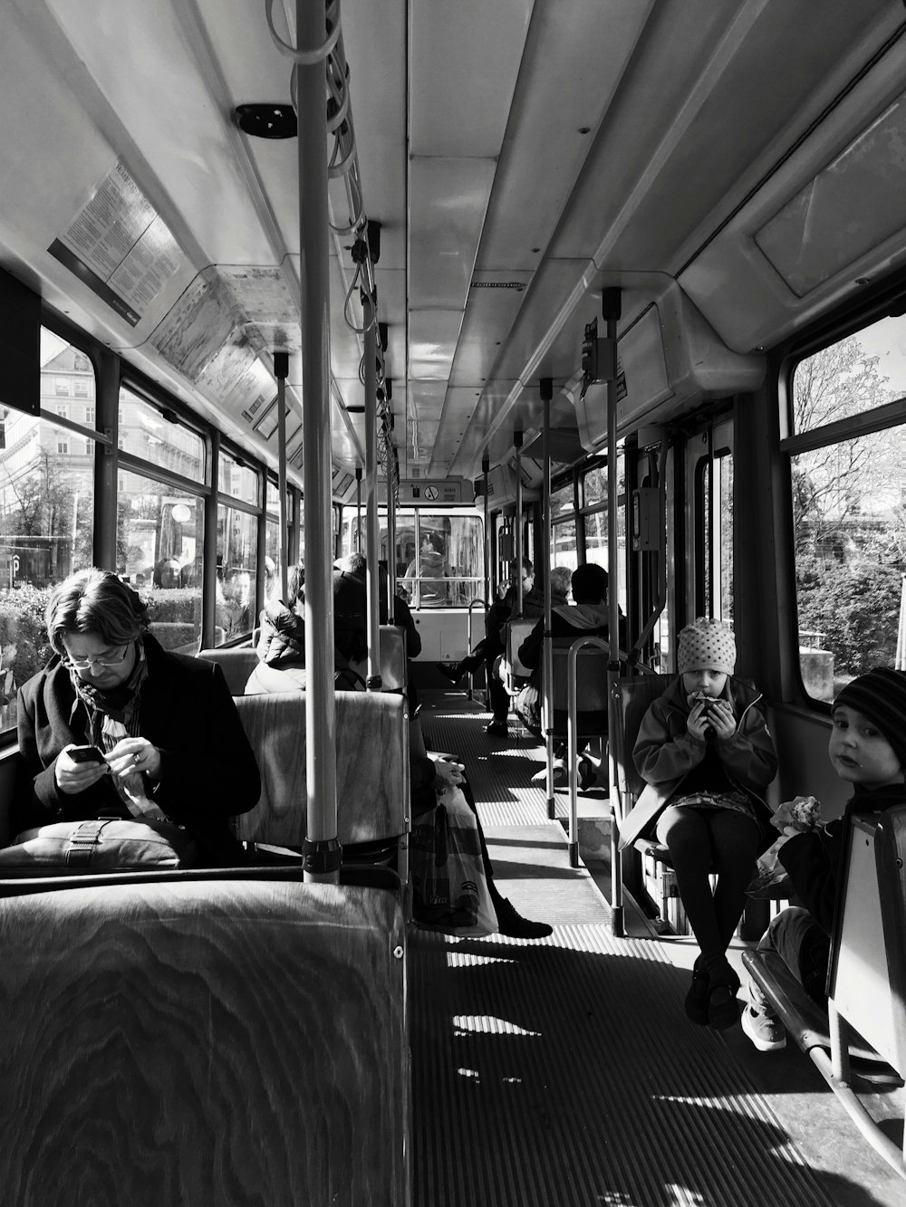 Foto in scala di grigi di una persona all'interno dell'autobus
