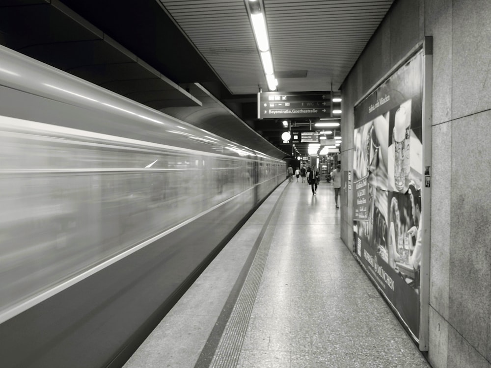 grayscale photo of people standing near train