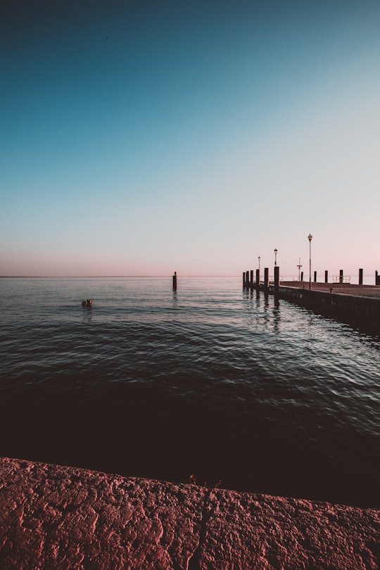 low-angle photo of dockside beside body of water in Lake Garda Italy