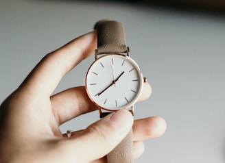 person holding analog watch