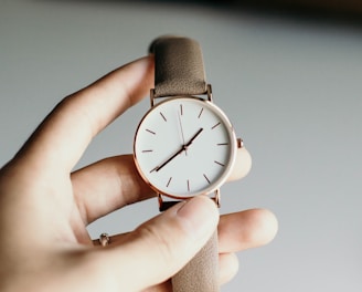 person holding analog watch