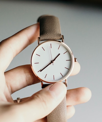 person holding analog watch