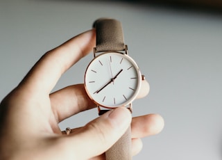 person holding analog watch