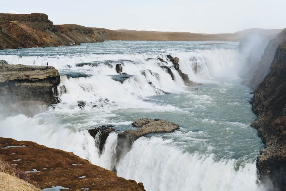 brown cliff surrounded body of water