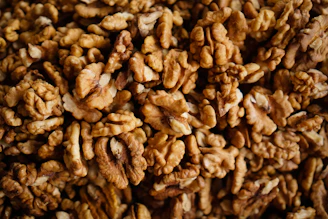 Close-up of a handful of glossy pecan nuts on a rustic wooden table