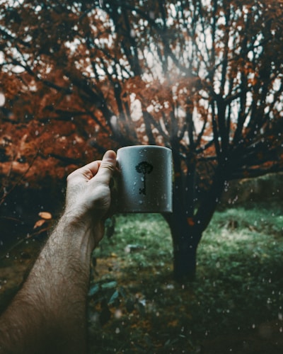 A close-up of a nature-themed mug with a forest silhouette and the words 'Breathe Deep' in elegant script.