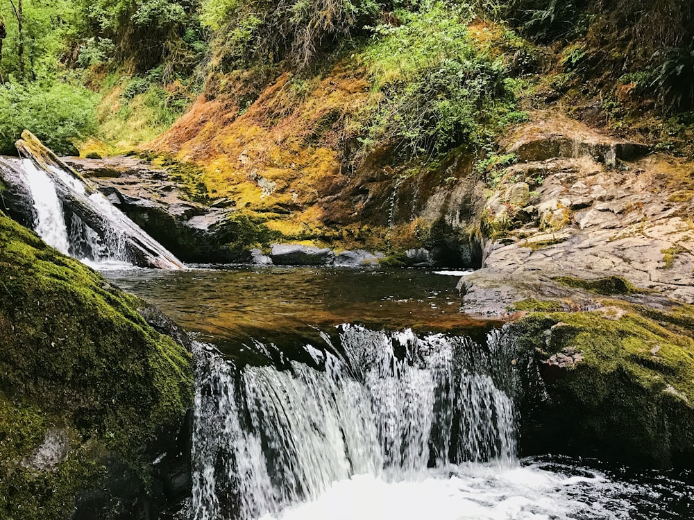 water falls on brown and green mountain