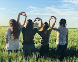 women forming heart gestures during daytime