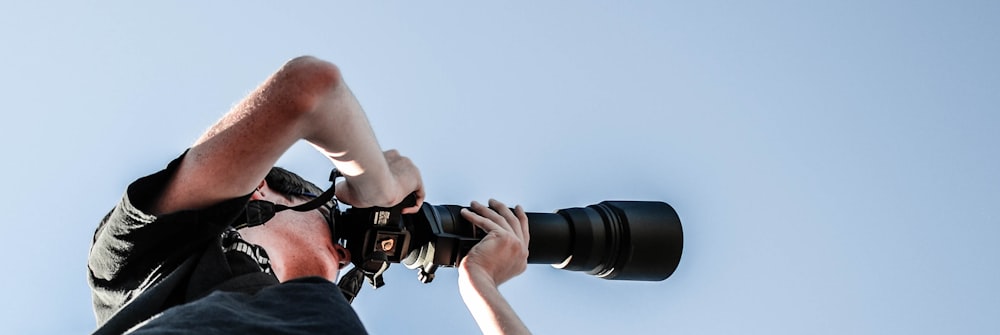 person holding black DSLR camera