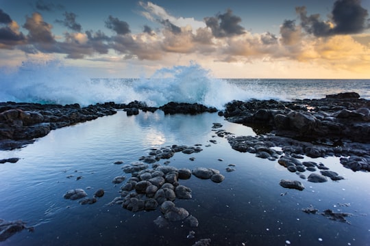 landscape photography of rocks and barrel wave in Glass Beach United States