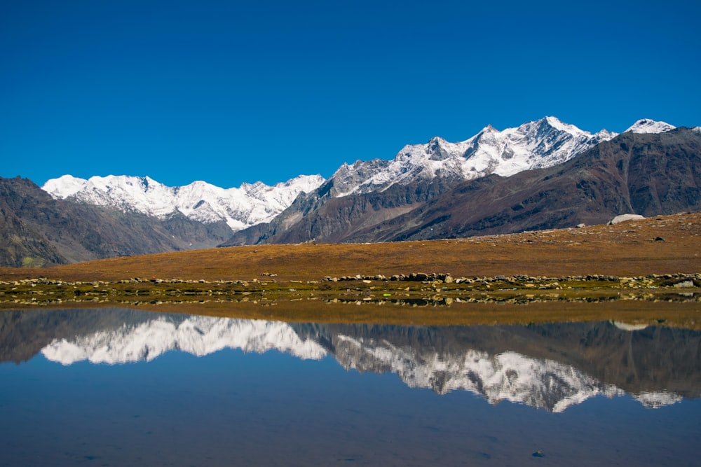 panoramic photographic of mountain reflecting on body of water