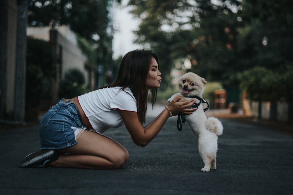 woman petting Pomeranian dog
