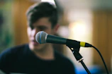 selective focus photography of black corded microphone on stand