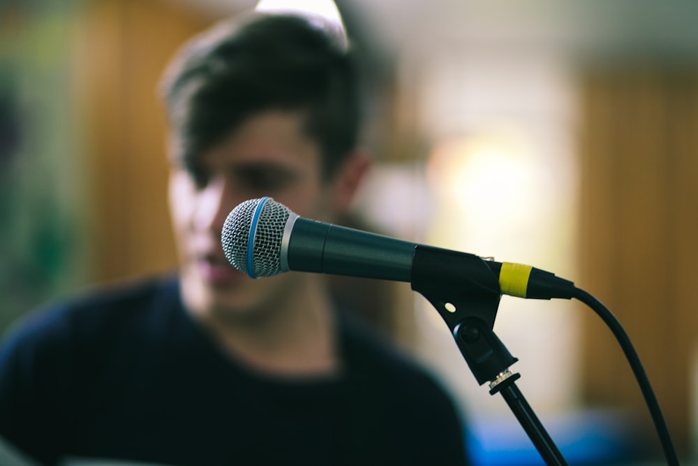 selective focus photography of black corded microphone on stand