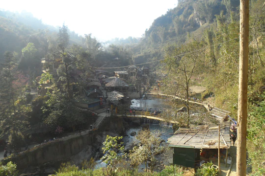 A serene tribal hillside retreat overlooking a flowing river at sunset, symbolizing harmony with nature.