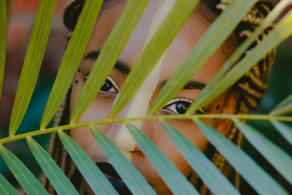 woman behind green leaf plant