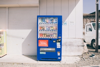 Technician performing maintenance on a smart vending machine with electric blue accents.