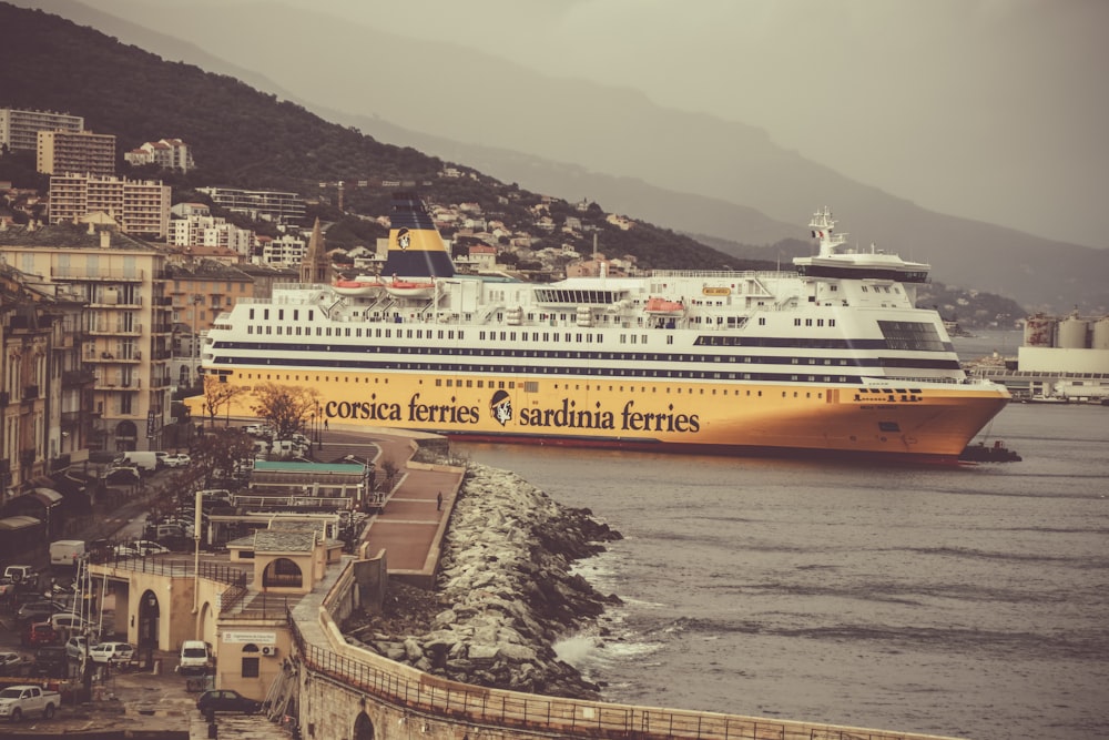 yellow and white cruise ship on body of water