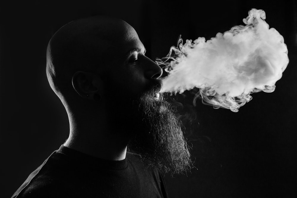 Mann raucht mit schwarzem Hintergrund