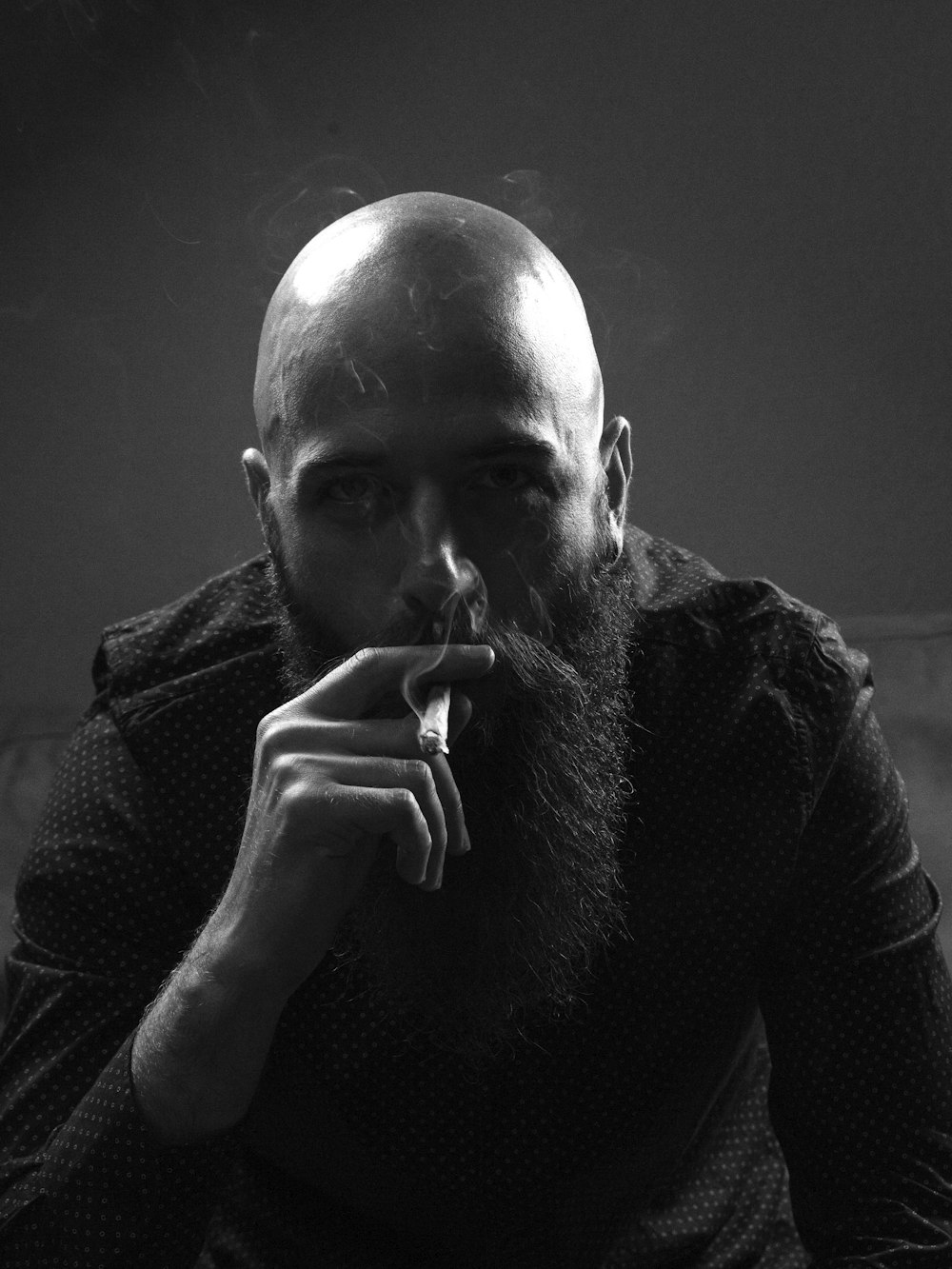 grayscale photo of man smoking cigarette