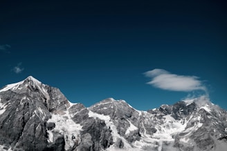 snow covered rocky mountain under clear sky at daytime