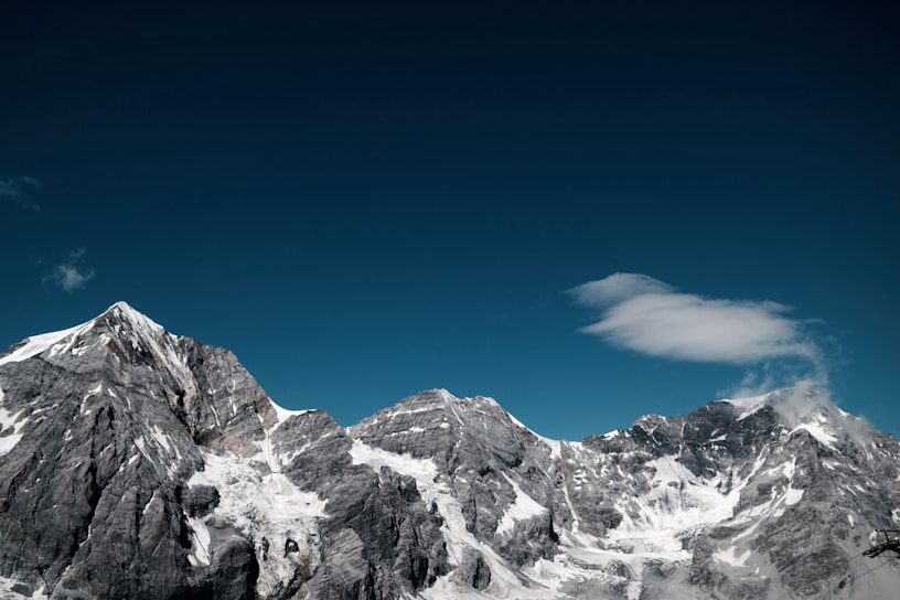 snow covered rocky mountain under clear sky at daytime