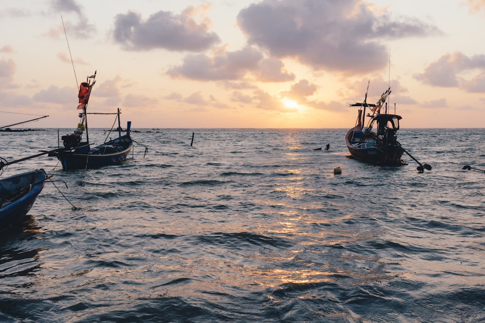 three boat on body of water during sunrise