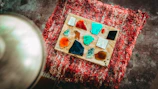 A collection of various stained glass panels displayed on a rustic wooden table.