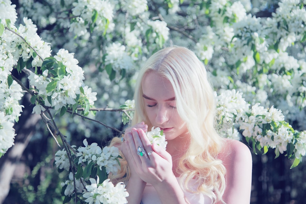 donna che sente l'odore del fiore durante il giorno