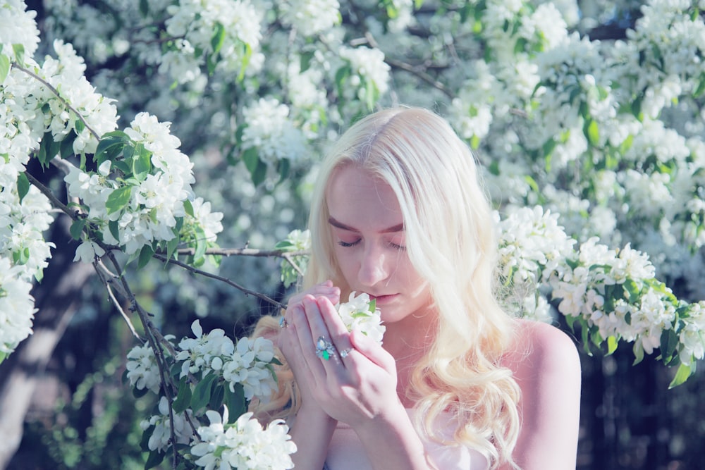 mulher cheirando flor durante o dia