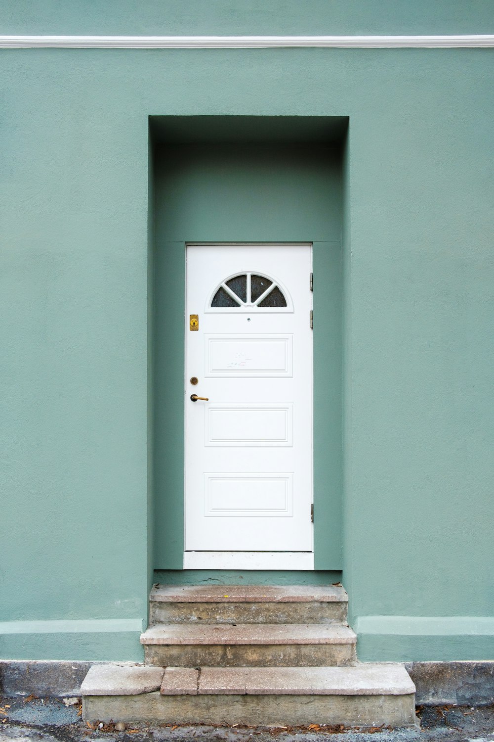 casa in cemento verde e bianco durante la foto diurna