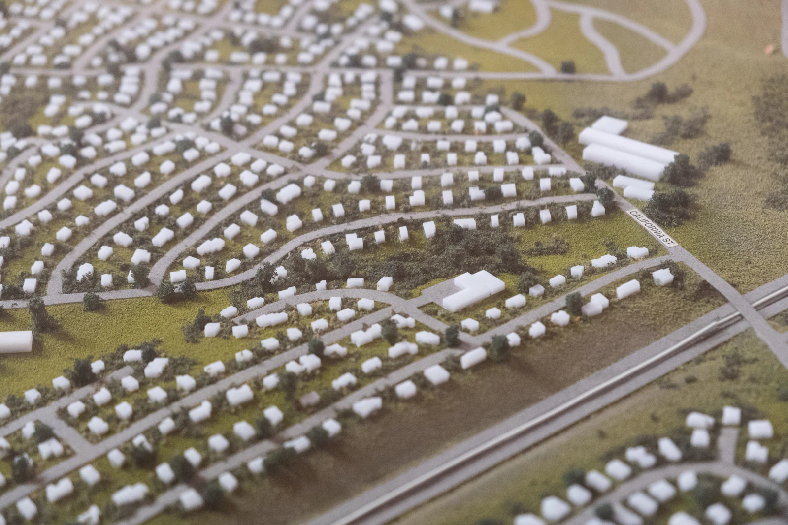 A large white architectural massing model of a planned district
