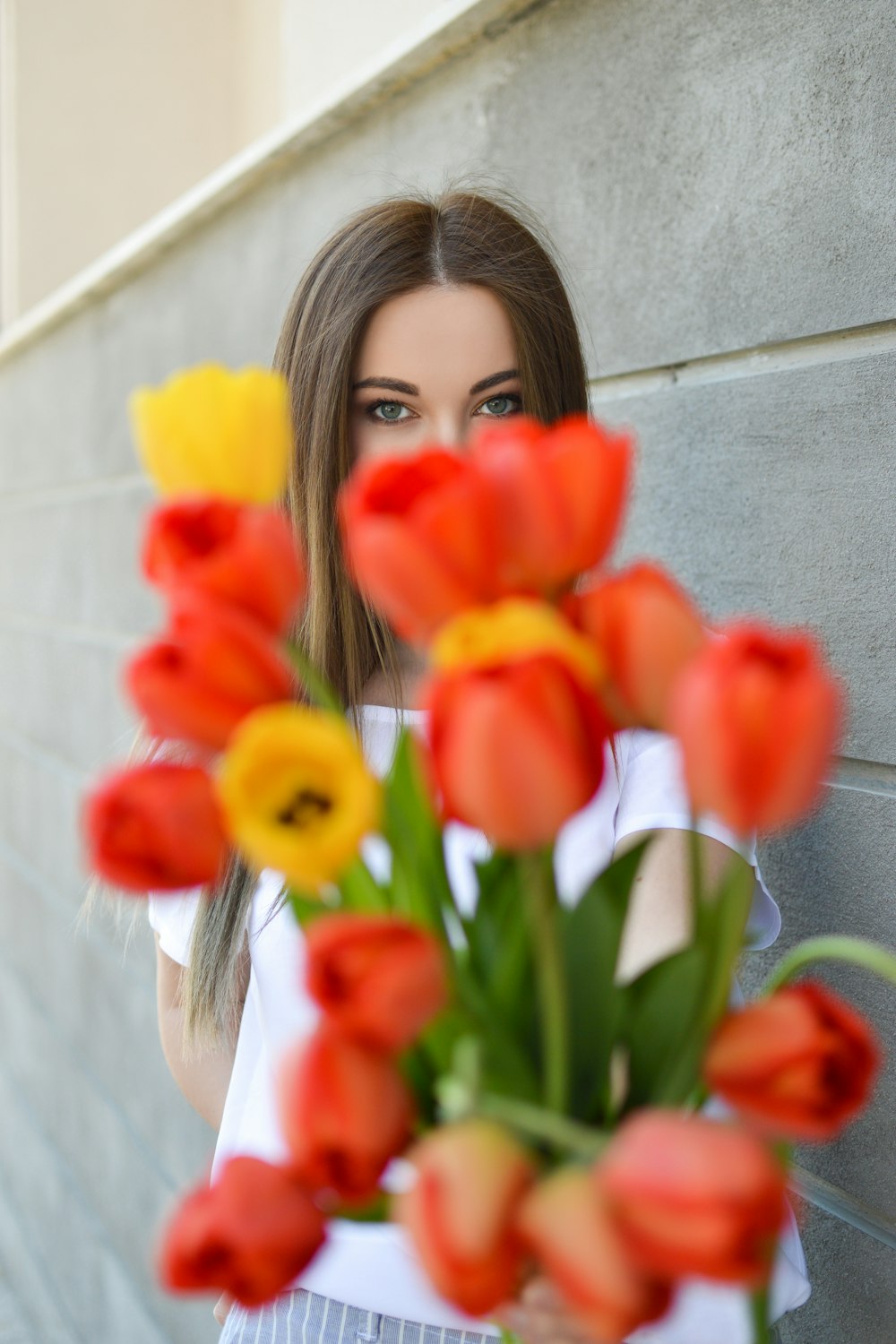 woman holding orange and yellow flowers