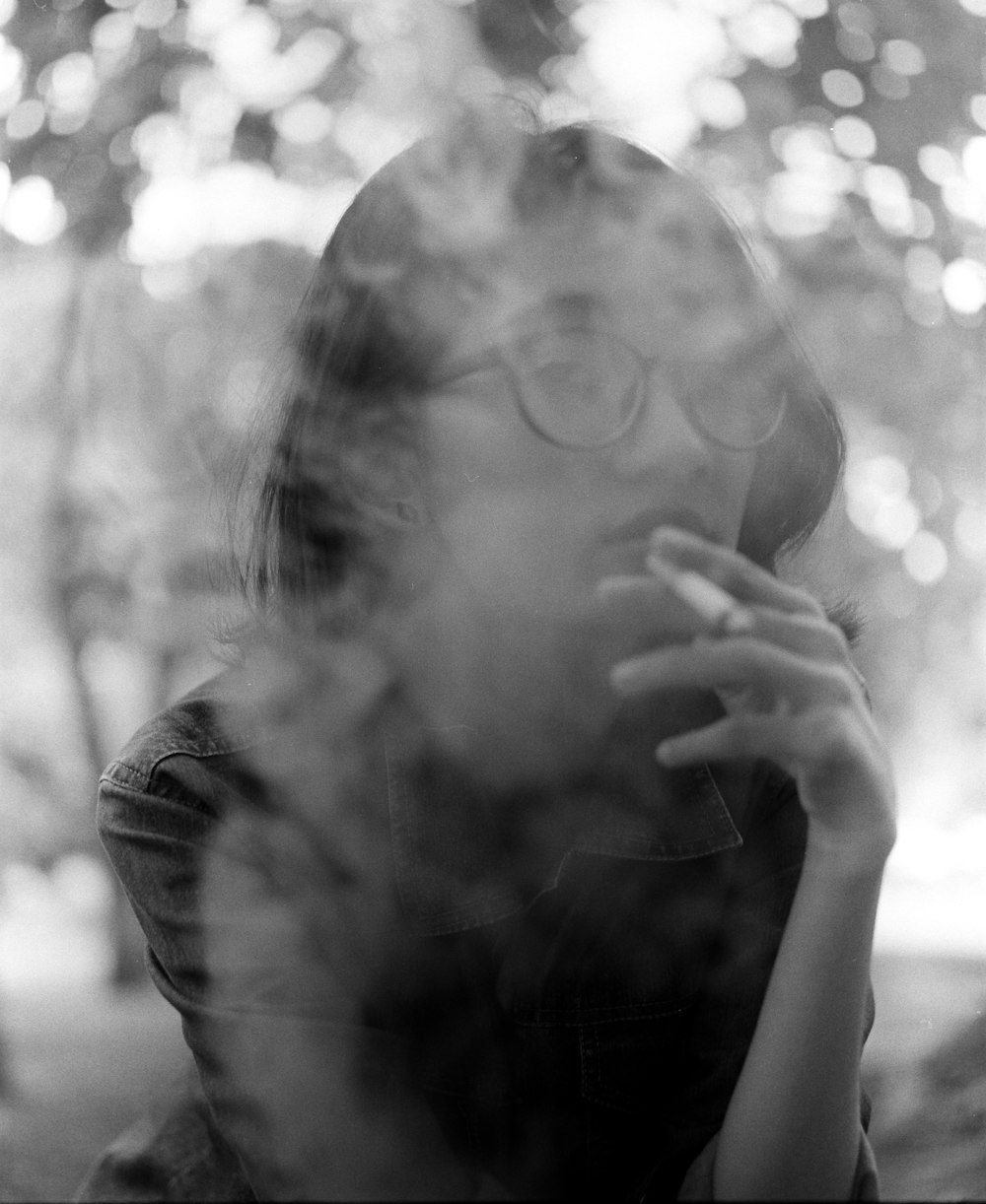 grayscale photo of woman smoking cigarette