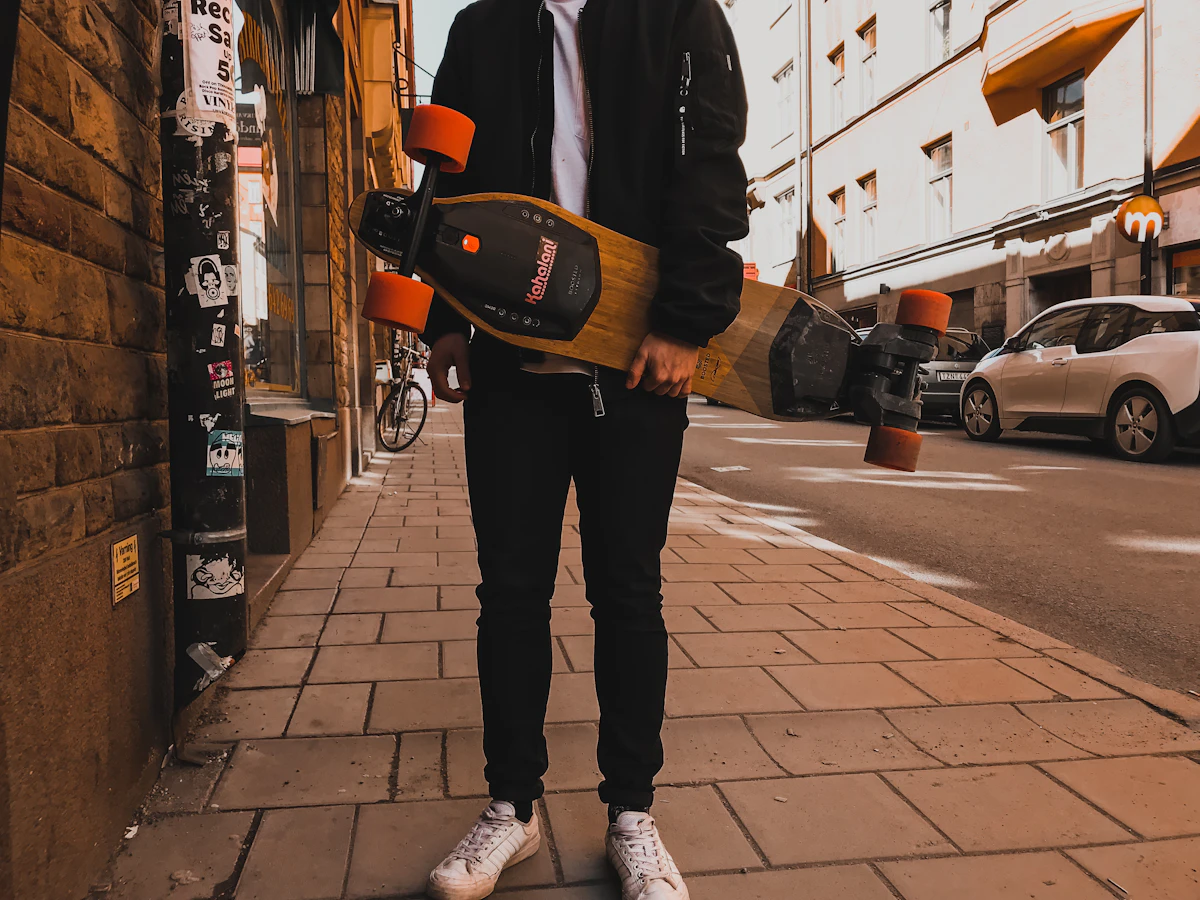Person carrying a skateboard as part of an active hobby