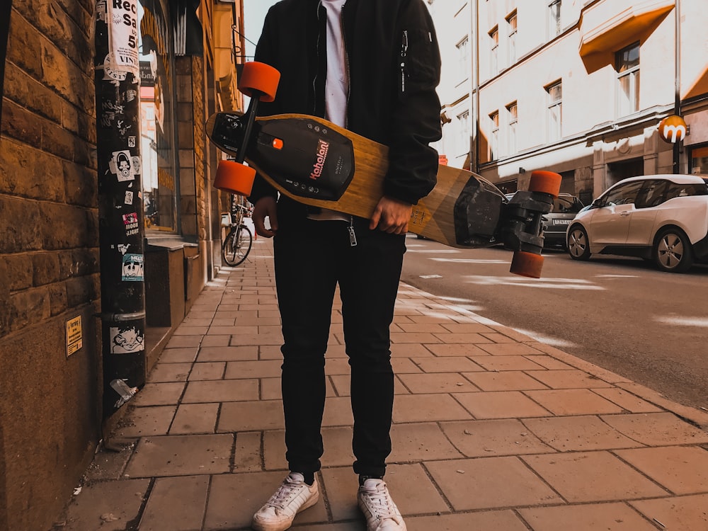 person holding skateboard near building