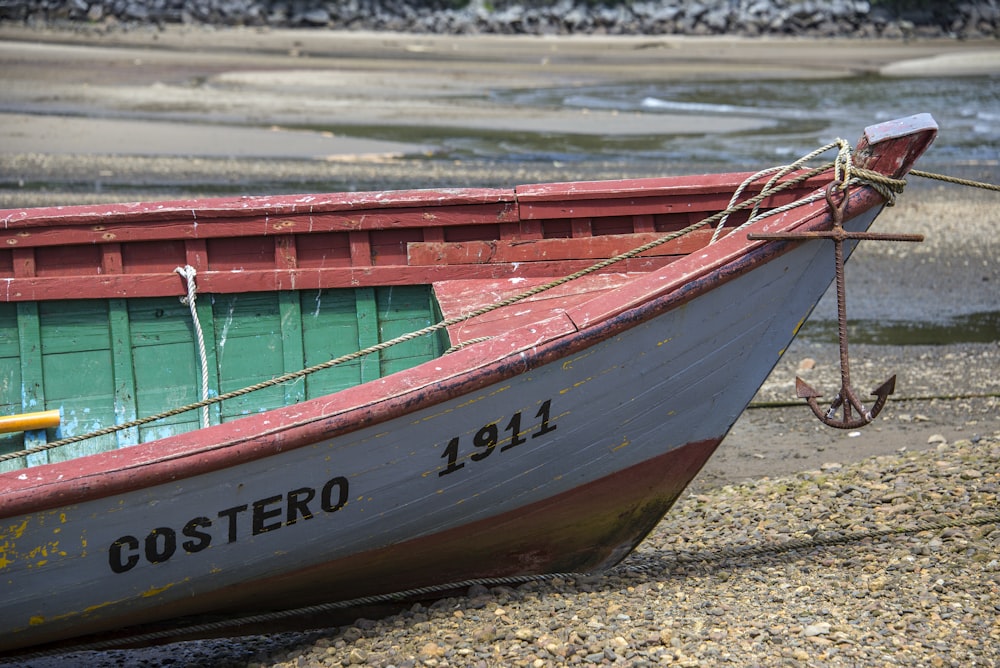 white and red Costero 1911 boat at shore