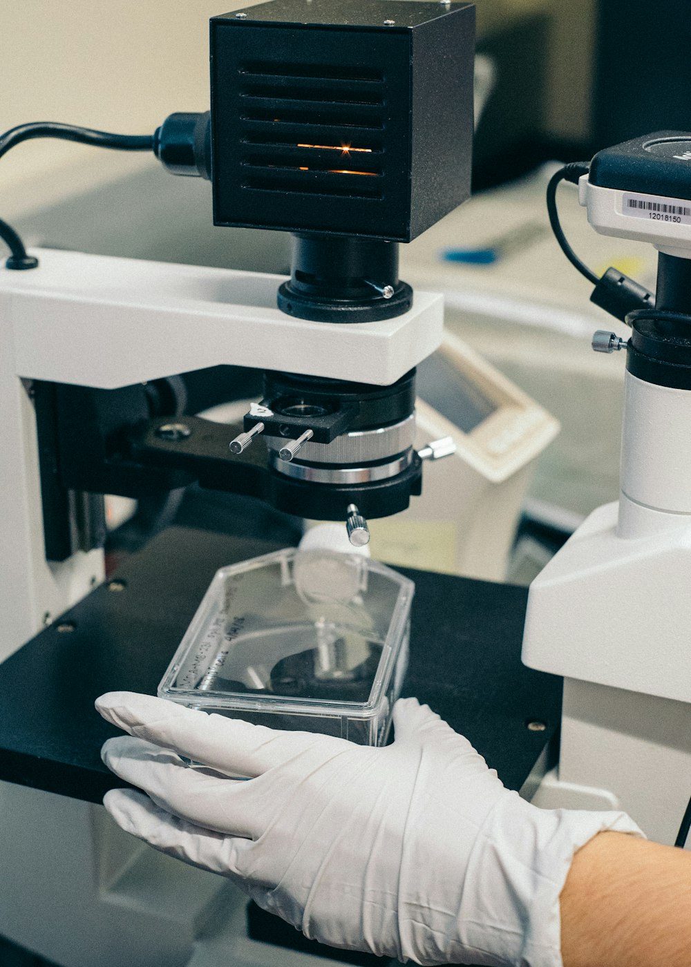 Persona sosteniendo un microscopio en blanco y negro