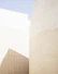 a man riding a skateboard down a street next to tall buildings