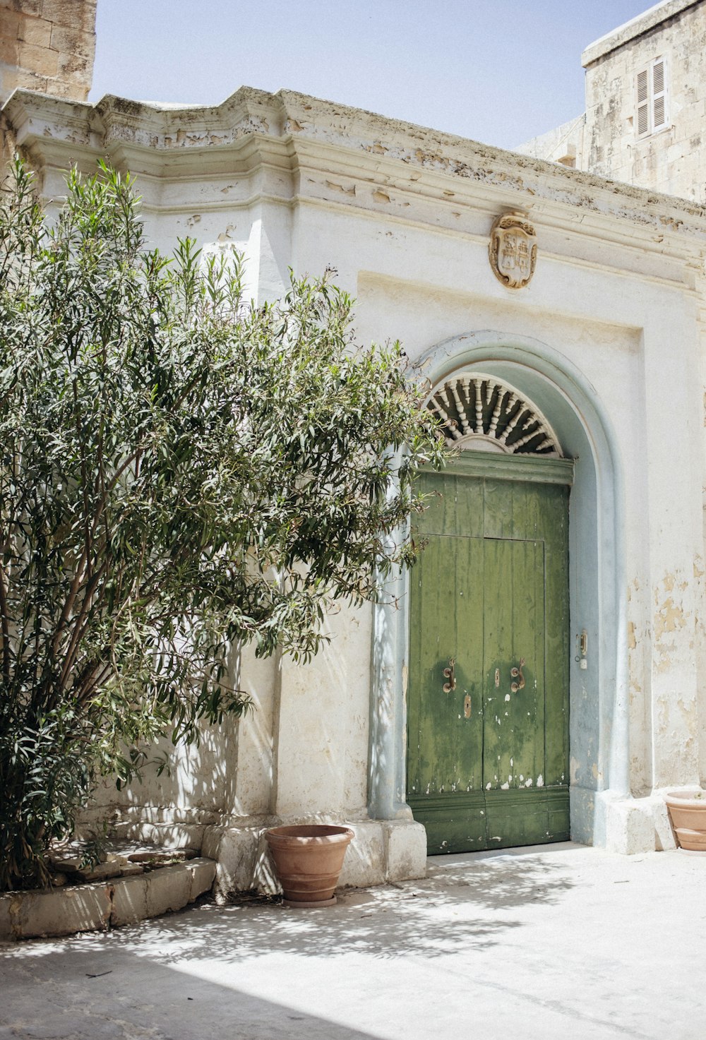 green wooden door is close of concrete building during daytime