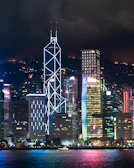 A shimmering neon-lit cyberpunk skyline with towering skyscrapers under a rain-soaked night sky.
