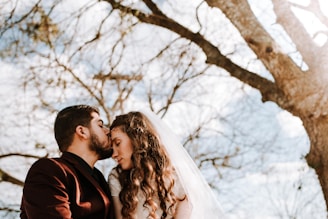 Groom wiping a tear during heartfelt vows in an outdoor garden setting