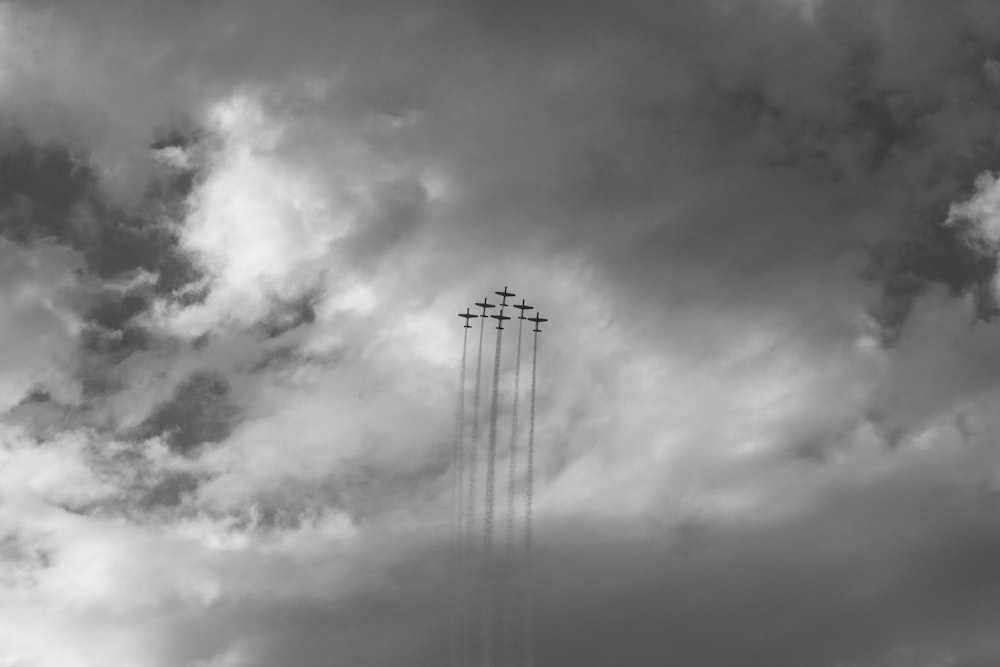 grayscale photo of six aircrafts creating contrails