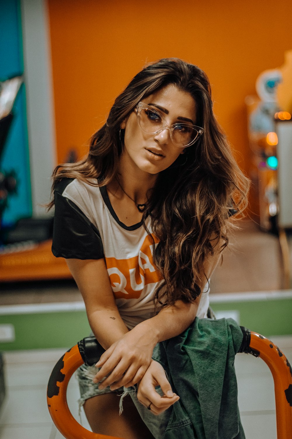 woman wearing eyeglasses leaning on yellow steel bar