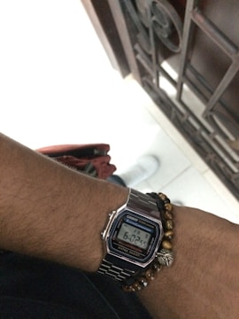 Close-up of a wristwatch showing morning time with jogging shoes nearby